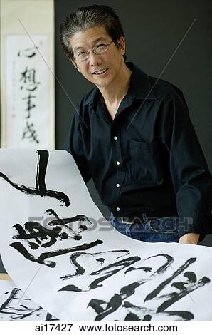 Man holding rice paper with Chinese calligraphy View Large Photo Image Stock Photo - Man holding rice paper with Chinese calligraphy . Fotosearch