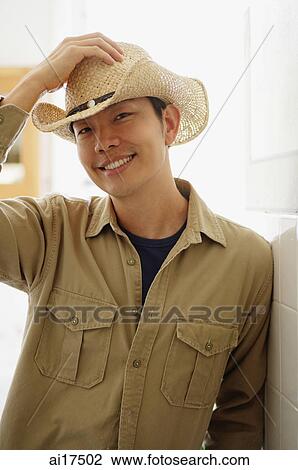 Man in cowboy hat, hand on head, smiling at camera View Large Photo Image Stock Image - Man in cowboy hat, hand on head, smiling at camera. Fotosearch