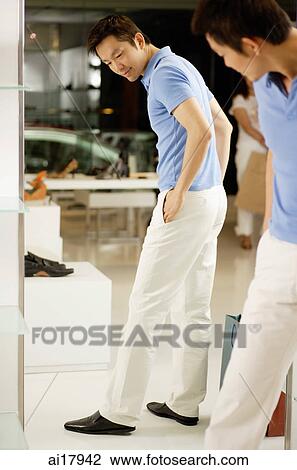 Man in shoe shop trying on shoes, looking at mirror View Large Photo Image Stock Image - Man in shoe shop trying on shoes, looking at mirror . Fotosearch