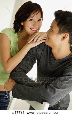 Man leaning arms on back of chair, looking at woman leaning on his shoulder View Large Photo Image Stock Image - Man leaning arms on back of chair, looking at woman leaning on his shoulder . Fotosearch