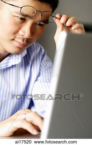 Man looking at laptop, raising eyeglasses View Large Photo Image Stock Image - Man looking at laptop, raising eyeglasses . Fotosearch