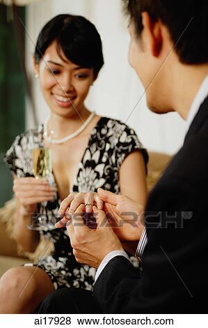 Man placing ring on womans finger View Large Photo Image Stock Photo - Man placing ring on womans finger . Fotosearch