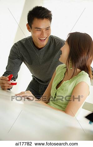Stock Image - Man presenting woman with ring in box . Fotosearch