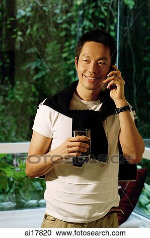 Man using mobile phone, holding drink View Large Photo Image Stock Image - Man using mobile phone, holding drink. Fotosearch