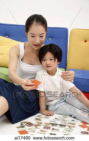 Mother and daughter sitting on floor, playing cards View Large Photo Image Stock Image - Mother and daughter sitting on floor, playing cards . Fotosearch