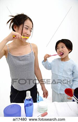 Mother and young daughter brushing teeth, looking at each other View Large Photo Image Stock Image - Mother and young daughter brushing teeth, looking at each other . Fotosearch