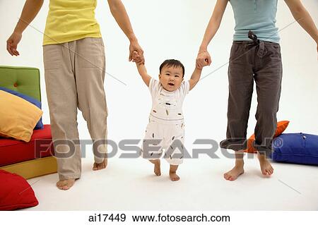 Parents holding hands with toddler View Large Photo Image Stock Photo - Parents holding hands with toddler . Fotosearch