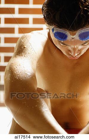 Swimmer sitting, arms resting on knees, looking down View Large Photo Image Picture - Swimmer sitting, arms resting on knees, looking down . Fotosearch
