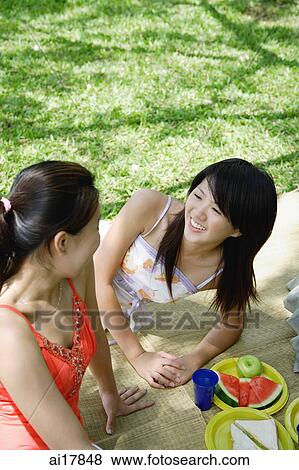 Two women having a picnic in park View Large Photo Image Stock Photo - Two women having a picnic in park . Fotosearch