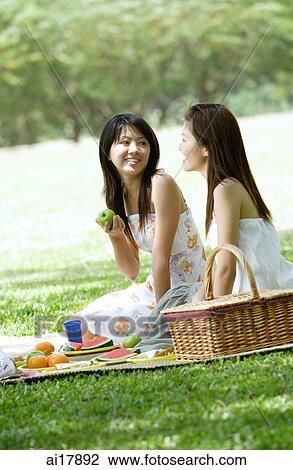 Two young women having a picnic View Large Photo Image Stock Image - Two young women having a picnic. Fotosearch