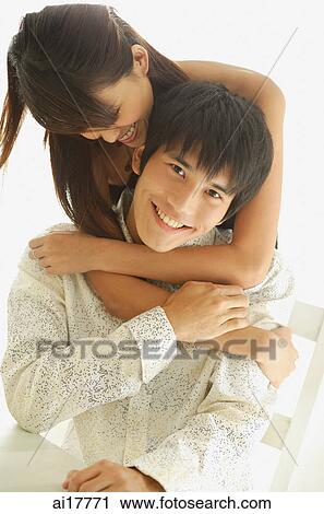 Woman embracing man, man smiling at camera View Large Photo Image Stock Image - Woman embracing man, man smiling at camera . Fotosearch