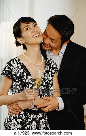 Woman holding glass of champagne, man kissing her neck View Large Photo Image Stock Image - Woman holding glass of champagne, man kissing her neck. Fotosearch