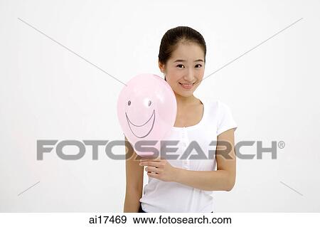 Woman holding pink balloon with smiley face drawn on it View Large Photo Image Stock Photo - Woman holding pink balloon with smiley face drawn on it . Fotosearch