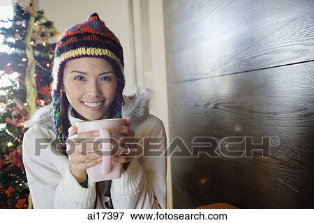 Woman in jacket and cap, holding mug in both hands View Large Photo Image Stock Photo - Woman in jacket and cap, holding mug in both hands . Fotosearch