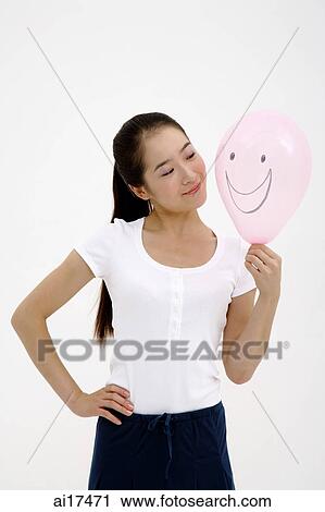 Woman looking at pink balloon, hand on hip View Large Photo Image Stock Image - Woman looking at pink balloon, hand on hip . Fotosearch
