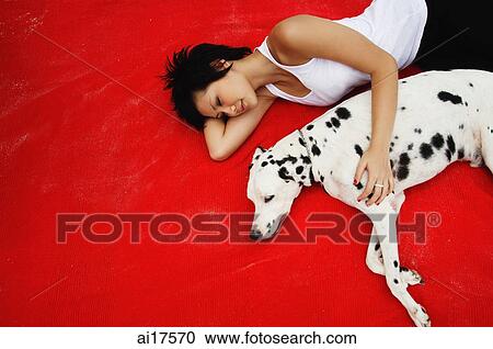 Woman lying down with Dalmatian on red blanket View Large Photo Image Stock Image - Woman lying down with Dalmatian on red blanket . Fotosearch