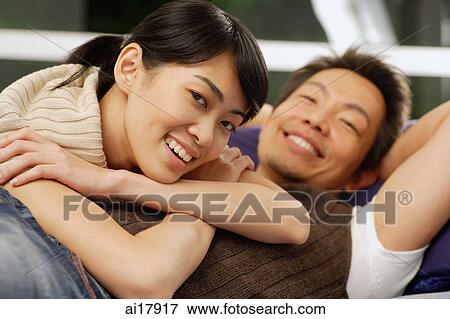 Woman lying over mans torso, both smiling at camera View Large Photo Image Stock Photo - Woman lying over mans torso, both smiling at camera. Fotosearch