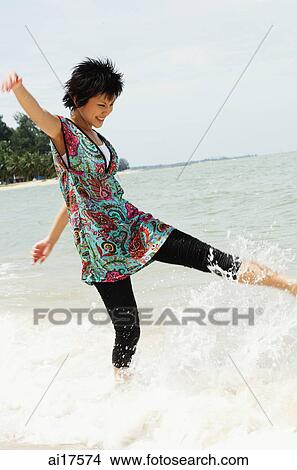Woman on beach, kicking water View Large Photo Image Picture - Woman on beach, kicking water . Fotosearch