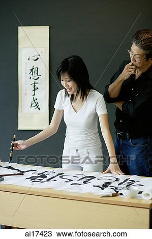 Woman painting Chinese calligraphy, man next to him watching View Large Photo Image Stock Image - Woman painting Chinese calligraphy, man next to him watching . Fotosearch
