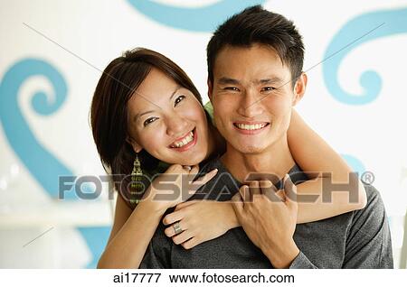 Woman with arm around man, both smiling at camera View Large Photo Image Stock Photo - Woman with arm around man, both smiling at camera . Fotosearch