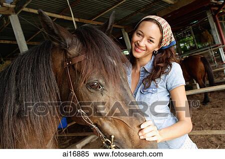 Stock Photography - Woman with horse in stable . Fotosearch