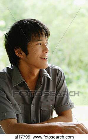 Young man sitting, looking away View Large Photo Image Stock Photography - Young man sitting, looking away . Fotosearch