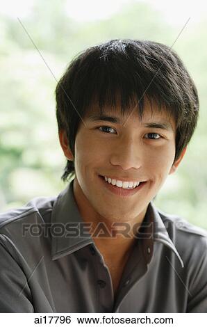 Young man smiling at camera, head shot View Large Photo Image Stock Photograph - Young man smiling at camera, head shot. Fotosearch