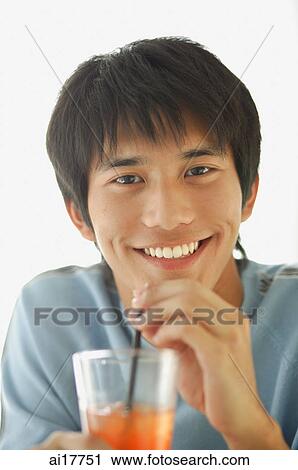 Young man with drink, smiling at camera View Large Photo Image Stock Image - Young man with drink, smiling at camera. Fotosearch