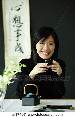 Young woman drinking Chinese tea, smiling at camera View Large Photo Image Stock Photo - Young woman drinking Chinese tea, smiling at camera . Fotosearch