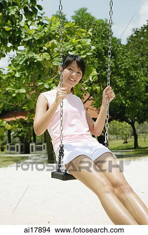 Young woman on swing at playground View Large Photo Image Picture - Young woman on swing at playground . Fotosearch