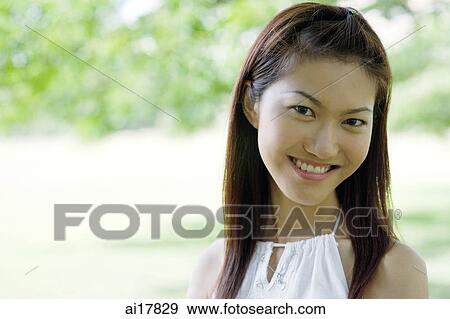 Young woman smiling at camera, head shot View Large Photo Image Stock Photo - Young woman smiling at camera, head shot . Fotosearch