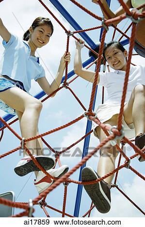 Young women climbing ropes at playground, smiling at camera View Large Photo Image Stock Photo - Young women climbing ropes at playground, smiling at camera . Fotosearch