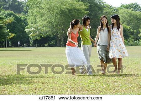 Young women in park, walking side by side View Large Photo Image Stock Image - Young women in park, walking side by side . Fotosearch