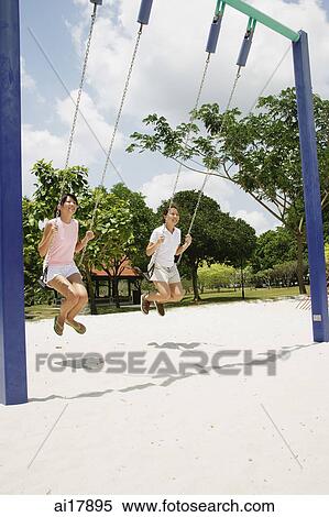 Young women on swings at playground View Large Photo Image Stock Photography - Young women on swings at playground . Fotosearch