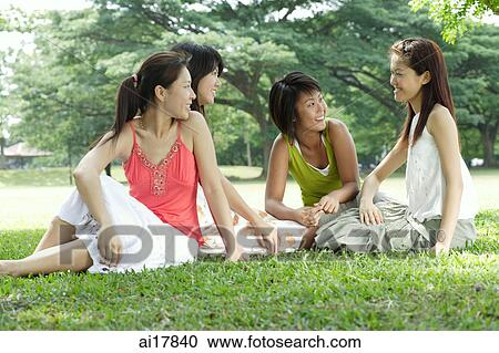 Stock Image - Young women sitting in park. Fotosearch