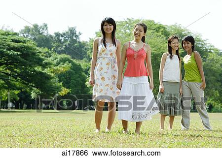 Young women standing side by side in field View Large Photo Image Stock Photograph - Young women standing side by side in field. Fotosearch