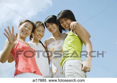Young women standing side by side, looking at camera, smiling View Large Photo Image Stock Photography - Young women standing side by side, looking at camera, smiling . Fotosearch