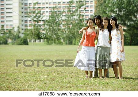 Young women standing together, smiling at camera View Large Photo Image Stock Photo - Young women standing together, smiling at camera . Fotosearch
