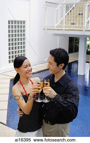 Couple by poolside, toasting with champagne View Large Photo Image Stock Photography - Couple by poolside, toasting with champagne . Fotosearch