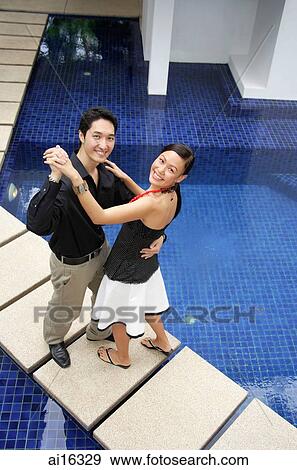Couple dancing by swimming pool, smiling at camera View Large Photo Image Stock Photo - Couple dancing by swimming pool, smiling at camera. Fotosearch