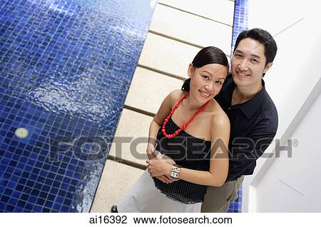 Couple embracing, smiling at camera, high angle view View Large Photo Image Stock Image - Couple embracing, smiling at camera, high angle view . Fotosearch