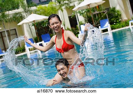 Couple in swimming pool, woman sitting on mans shoulders, splashing water View Large Photo Image Stock Image - Couple in swimming pool, woman sitting on mans shoulders, splashing water . Fotosearch