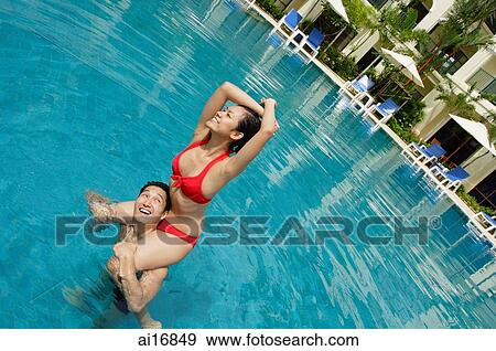 Couple in swimming pool, woman sitting on mans shoulders, looking away View Large Photo Image Stock Photo - Couple in swimming pool, woman sitting on mans shoulders, looking away. Fotosearch