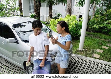 Couple next to car, man with soap suds on face, woman next to him, laughing View Large Photo Image Stock Image - Couple next to car, man with soap suds on face, woman next to him, laughing . Fotosearch