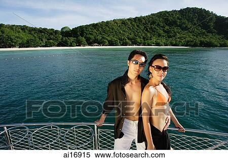 Couple on boat deck, looking at camera View Large Photo Image Stock Photography - Couple on boat deck, looking at camera . Fotosearch