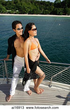 Couple on boat deck, man with arms around woman View Large Photo Image Stock Image - Couple on boat deck, man with arms around woman . Fotosearch