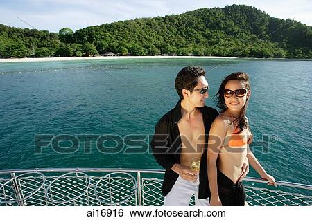 Couple on boat deck, standing next to railing View Large Photo Image Stock Photograph - Couple on boat deck, standing next to railing . Fotosearch