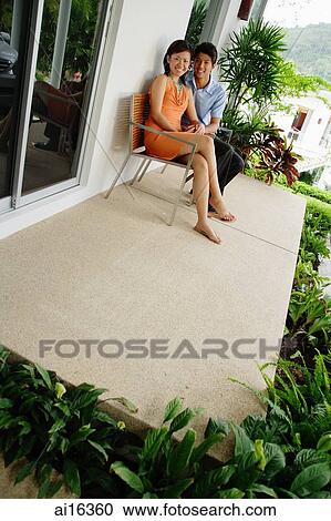 Stock Image - Couple sitting on patio . Fotosearch