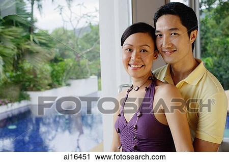 Couple standing next to a window, looking at camera View Large Photo Image Stock Image - Couple standing next to a window, looking at camera . Fotosearch
