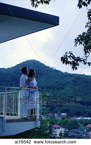 Couple standing on balcony, side view View Large Photo Image Stock Image - Couple standing on balcony, side view . Fotosearch
